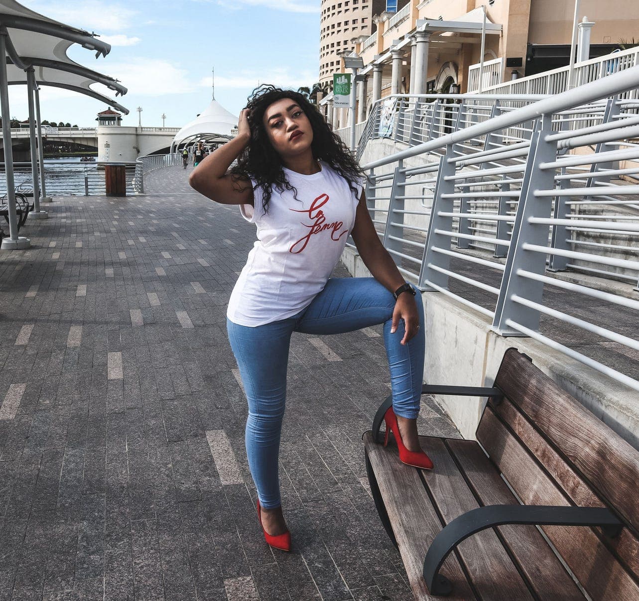 Graphic drop-shoulder top styled with jeans and red heels