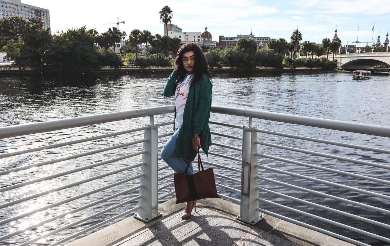 Teal green cardigan styled with jeans, a tote, and neutral heels